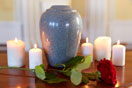 cremation urn with red rose and burning candles