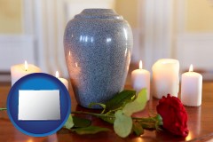 colorado map icon and cremation urn with red rose and burning candles