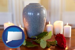 connecticut map icon and cremation urn with red rose and burning candles