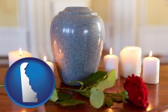 delaware map icon and cremation urn with red rose and burning candles