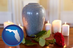 florida map icon and cremation urn with red rose and burning candles