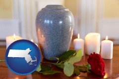massachusetts map icon and cremation urn with red rose and burning candles