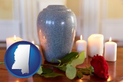 mississippi map icon and cremation urn with red rose and burning candles