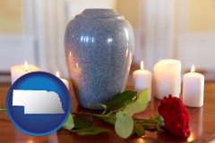 nebraska map icon and cremation urn with red rose and burning candles