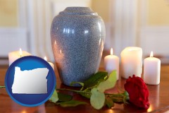 oregon map icon and cremation urn with red rose and burning candles