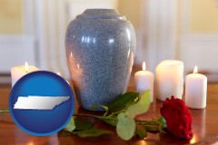 tennessee map icon and cremation urn with red rose and burning candles
