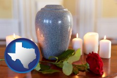texas map icon and cremation urn with red rose and burning candles